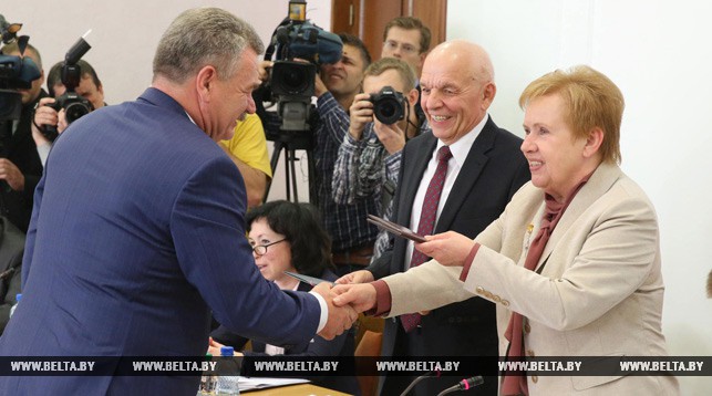 Председатель ЦИК Лидия Ермошина вручает удостоверение Николаю Улаховичу