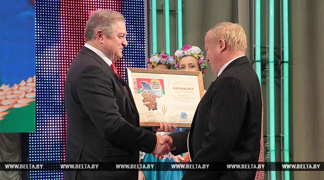 Семен Шапиро вручает награду главному агроному СПК "Нарочанские зори" Виктору Драчиловскому