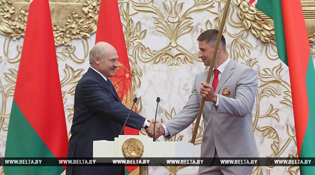 Александр Лукашенко вручает белорусский флаг Александру Богдановичу - капитану белорусской олимпийской сборной