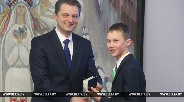 Игорь Бузовский вручает паспорт учащемуся Вольновской средней школы Барановичского района Никите Павлюченко.