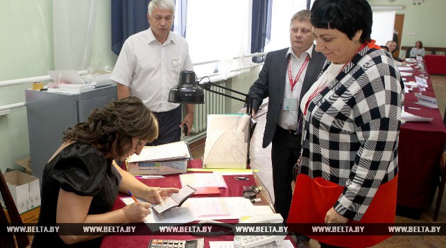 Международные наблюдатели от СНГ Наталья Канунникова и Александр Дрынов проходят регистрацию на избирательном участке в Гомеле.