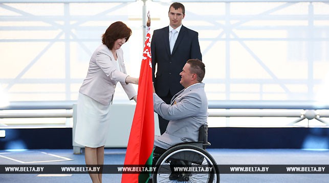 Наталья Кочанова вручает флаг знаменосцу белорусской делегации Александру Трипутю
