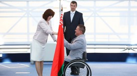 Наталья Кочанова вручает флаг знаменосцу белорусской делегации Александру Трипутю