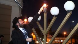 Раввин гродненской синагоги Ицхак Кофман зажигает ритуальный светильник, называемый ханукия
