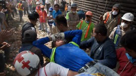 Спасатели и добровольцы перемещают пострадавшего человека (Мехико). Фото Синьхуа - БЕЛТА