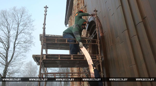 Плотники ОАО "Гродножилстрой" Павел Лукашевич и Дмитрий Поляков завершают отделочные работы - устанавливают капельник над входной дверью