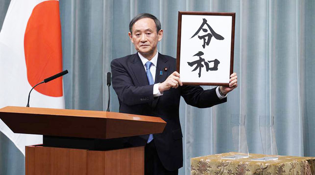 Генеральный секретарь кабинета министров Ёсихидэ Суга демонстрирует табличку со словом "Рэйва". Фото   AP Photo  