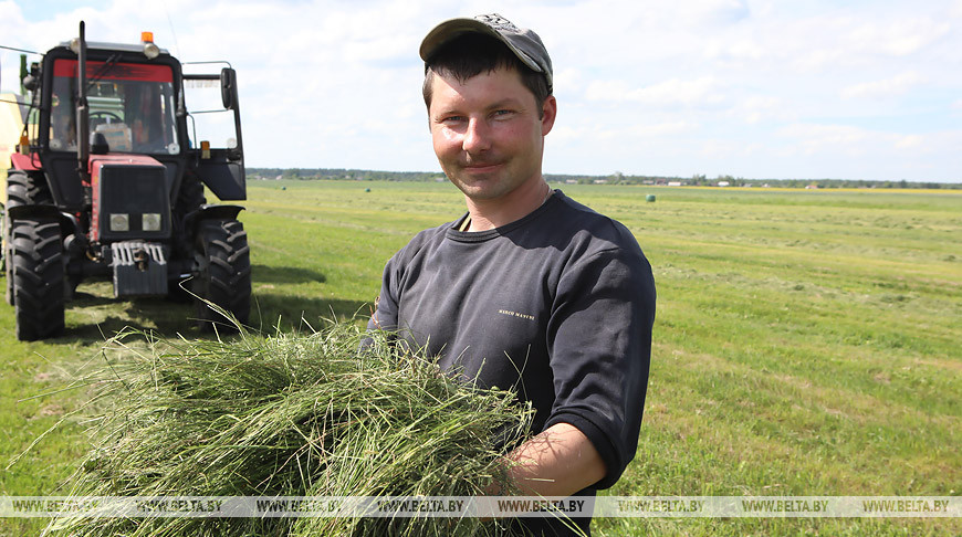 Механизатор Александр Ступень занят на подборке подвяленной травы и упаковке ее в полиэтиленовую пленку