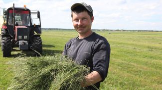 Механизатор Александр Ступень занят на подборке подвяленной травы и упаковке ее в полиэтиленовую пленку