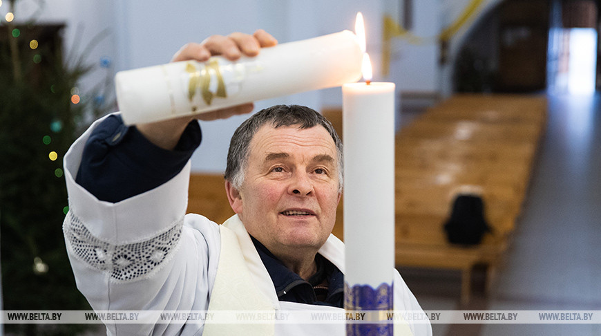 Ксендз Генрих Акалатович зажигает свечу от Вифлеемского огня мира