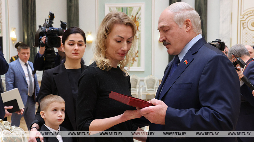 Александр Лукашенко вручает награду родственникам летчика Андрея Ничипорчика