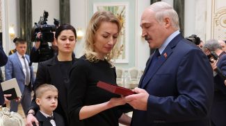 Александр Лукашенко вручает награду родственникам летчика Андрея Ничипорчика