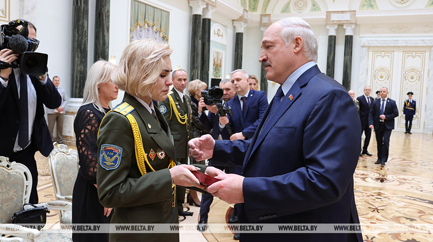 Александр Лукашенко вручает награду вдове летчика Никиты Куконенко