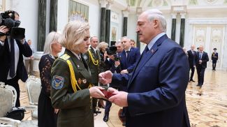 Александр Лукашенко вручает награду вдове летчика Никиты Куконенко