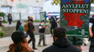 &quot;Остановите потоп просителей убежища&quot; - плакат на демонстрации ультраправых в Берлине. Фото Getty Images