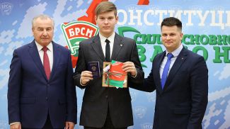 Петр Миклашевич и Александр Лукьянов вручают паспорт и памятные подарки Игнату Калиненко
