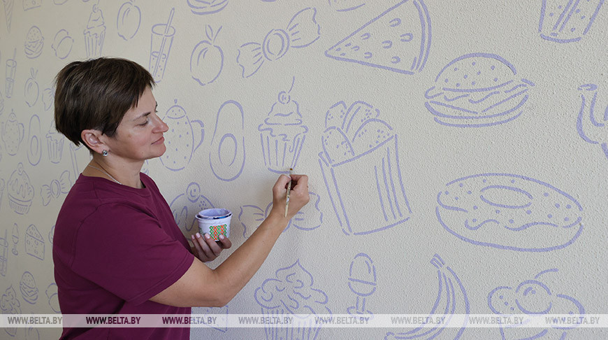 Преподаватель трудового обучения Людмила Ловцевич оформляет стены в столовой