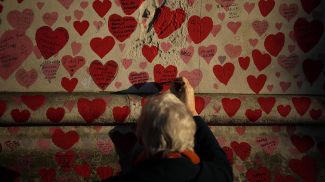Женщина у мемориальной стены в память о жертвах COVID-19 в Лондоне. Фото AP Photo