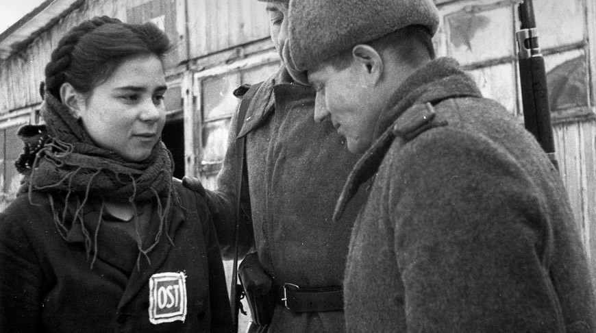 Красноармейцы беседуют с советской девушкой-остарбайтером, работавшей на немецком заводе "Юнкерс" в городе Познань, Польша