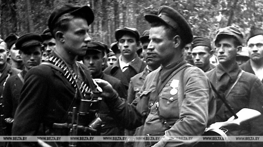Комиссар партизанского отряда Ф.И.Лисович (справа) вручает медаль партизану-разведчику комсомольцу Николаю Кулакевичу, 1943 год