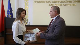 Председатель Комитета государственного контроля Гродненской области Анатолий Дорожко вручает сертификат Полине Дычек