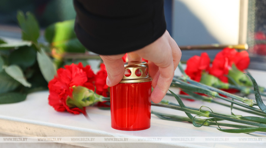 Люди несут цветы к посольству Казахстана в Беларуси