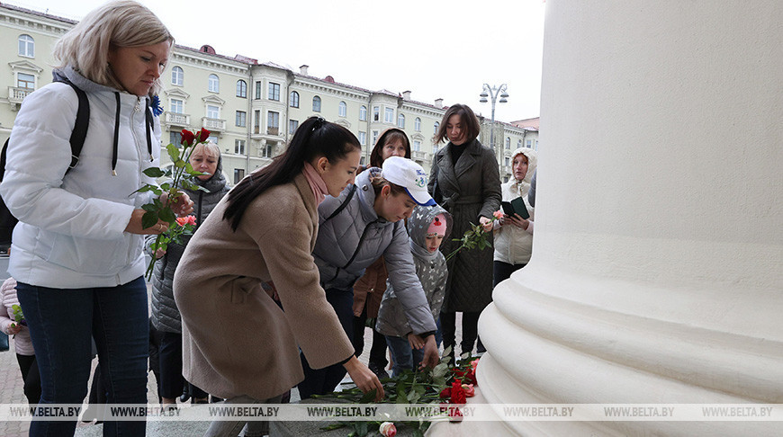 Люди несут цветы к Комитету госбезопасности в Минске в память о погибшем сотруднике