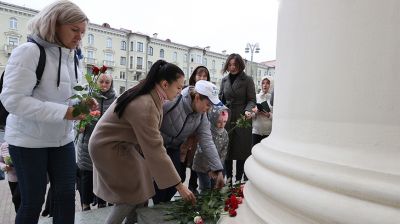 Люди несут цветы к Комитету госбезопасности в Минске в память о погибшем сотруднике