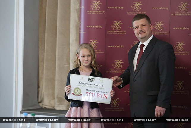 Заместитель председателя правления Нацбанка Сергей Калечиц награждает Веронику Митрахович, которая заняла третье место.