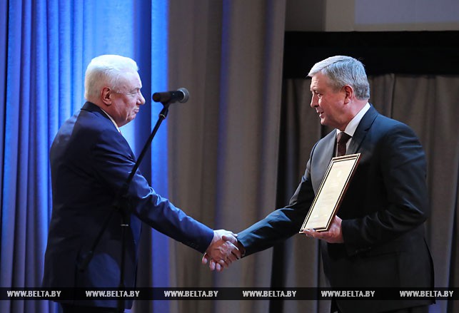 Заместитель премьер-министра Владимир Семашко награждает представителей научной общественности.