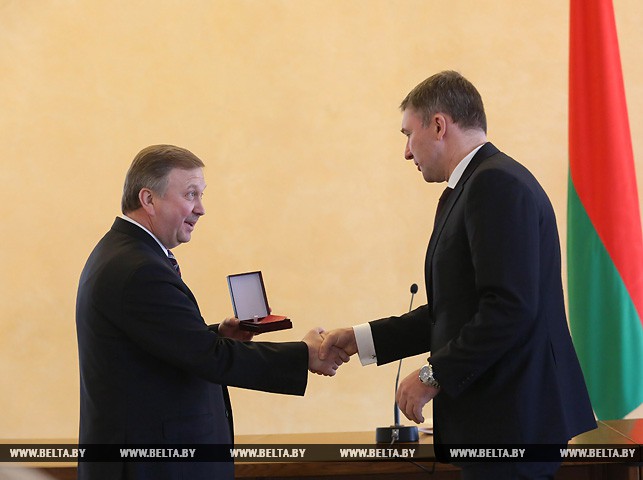 Андрей Кобяков вручает медаль "За трудовые заслуги" генеральному директору ЗАО "Полимастер" Дмитрию Бурому.