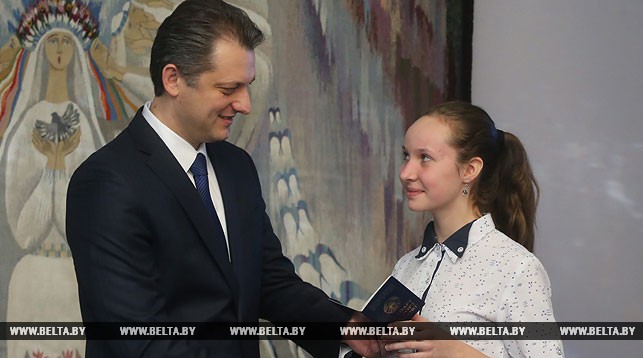 Игорь Бузовский вручает паспорт учащейся средней школы № 4 города Лиды Илоне Морочило
