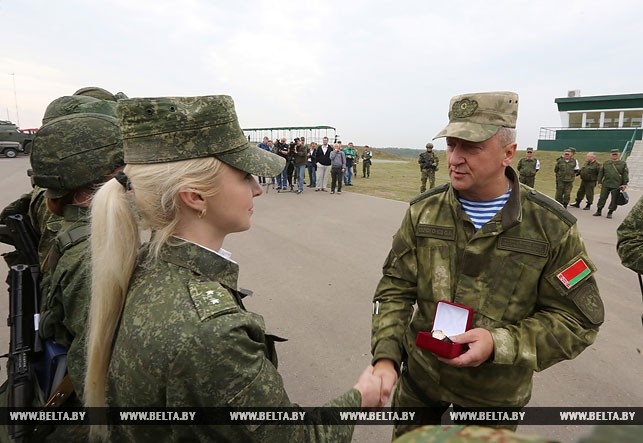Олег Белоконев вручает часы прапорщику медицинской службы Кристине Макаровой.
