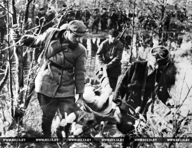 Партизаны бригады им. В.В. Куйбышева возвращаются с боевого задания с раненым товарищем. 1943 год