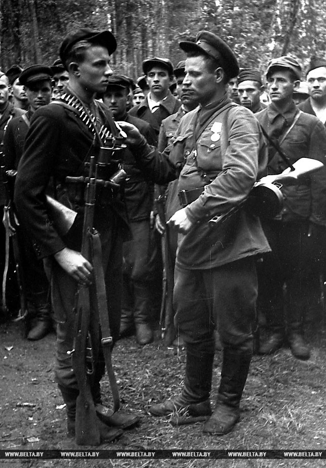 Комиссар партизанского отряда Ф.И.Лисович (справа) вручает медаль партизану-разведчику комсомольцу Николаю Кулакевичу. 1943 год