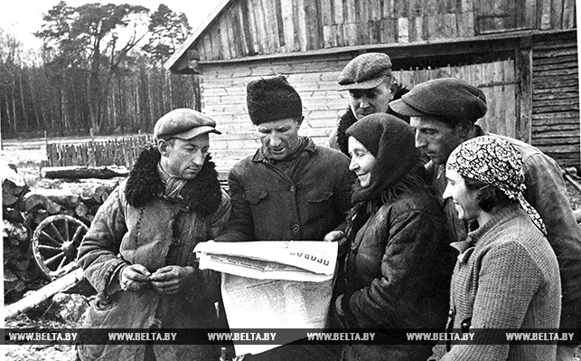 Группа бывших батраков польской помещицы Бынской, получивших землю, скот и жилье, читают газету "Правда"