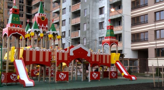 Детская площадка с огромным игровым городком и специальным мягким покрытием