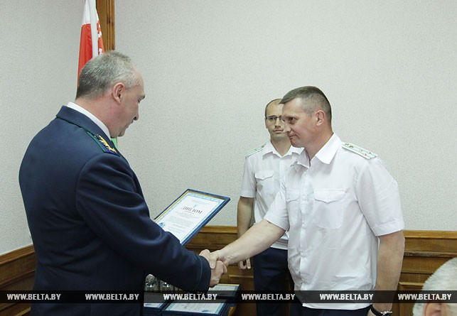 Александр Конюк награждает исполняющего обязанности прокурора Витебского района Михаила Шестопалова