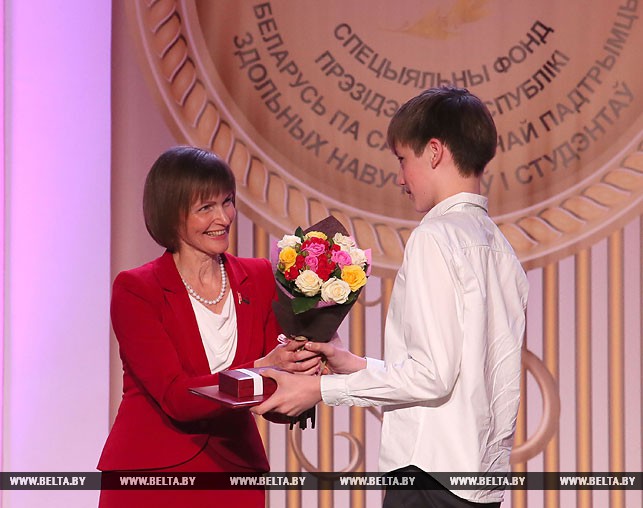 Председатель совета Специального фонда Президента Беларуси по поддержке талантливой молодежи Екатерина Дулова награждает Кирилла Атрощенко.
