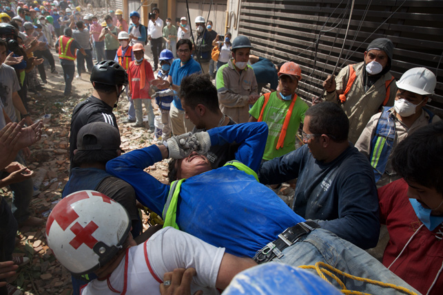 Спасатели и добровольцы перемещают пострадавшего человека (Мехико). Фото Синьхуа - БЕЛТА