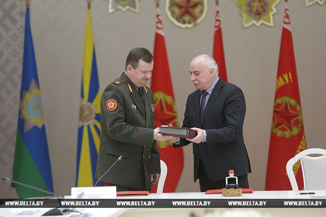 Министр связи и информатизации Сергей Попков вручает министру оброны Андрею Равкову альбом с марками, выпущенными за все время независимости Беларуси.
