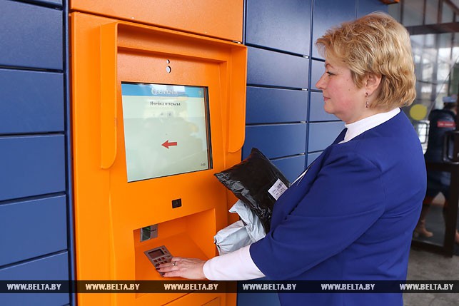 Начальник отделения почтовой связи №25 Алла Титова наполняет посылками ячейки почтомата.