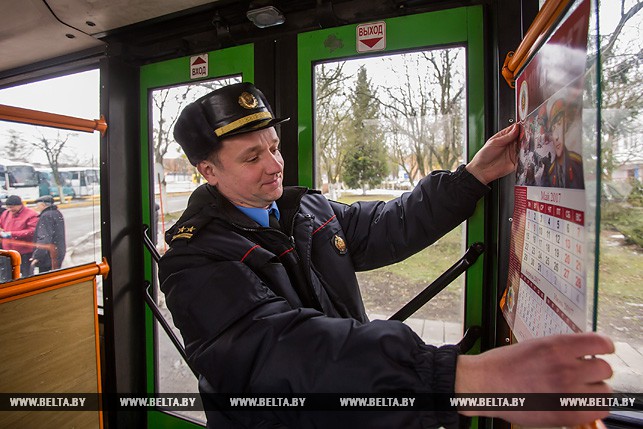 Начальник пресс-службы УВД Брестского облисполкома Сергей Дученко украшает тематический автобус календарём