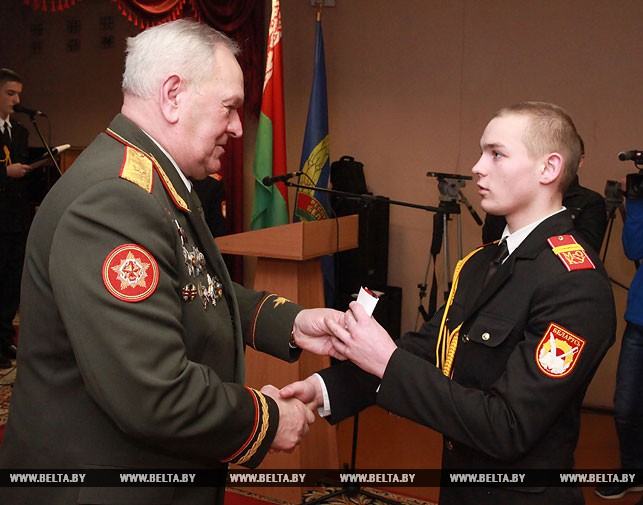 Председатель центрального совета ДОСААФ Иван Дырман вручает погоны курсанту Александру Толкачеву.