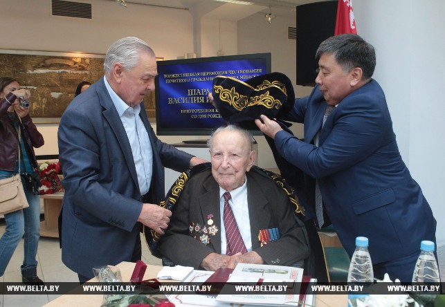 Бывший министр транспортного строительства Казахстана Шамиль Бекбулатов (слева) поздравляет юбиляра и дарит ему национальный казахский костюм