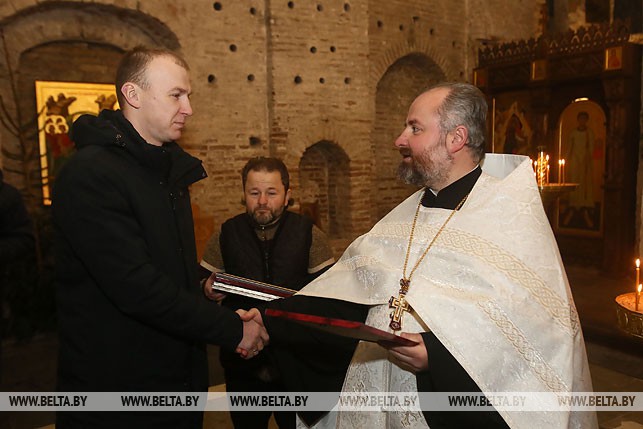 Настоятель Коложской церкви протоиерей Александр Болонников (справа) награждает грамотой Андрея Тараса