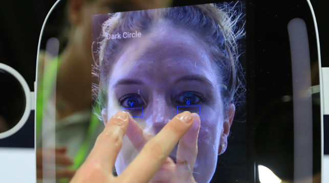 Девушка тестирует интеллектуальное зеркало, которое может показать проблемы с кожей