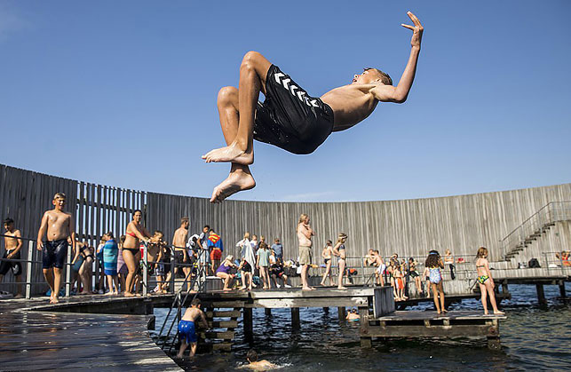 Мальчик прыгает в воду в Amager Beach Park в Копенгагене. Фото EPA
