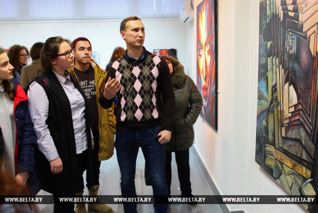 Художник Федор Бажин рассказывает посетителям выставке о своей картине.