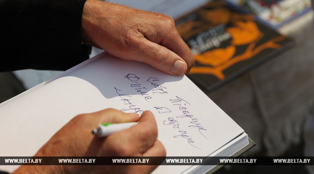 Писатель Михаил Бусько подписывает автограф своему читателю
